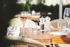 Et glas rosé på et opdækket bord. Udenfor i solen på restauranten Il Rosmarino på Nyhavn