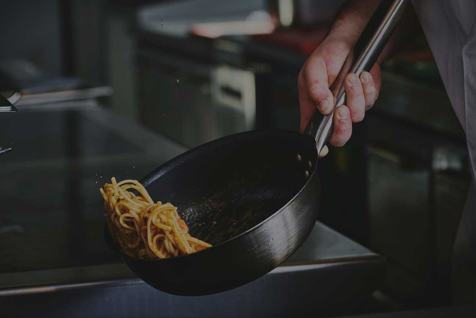 En kok der laver italiensk pasta i en pande